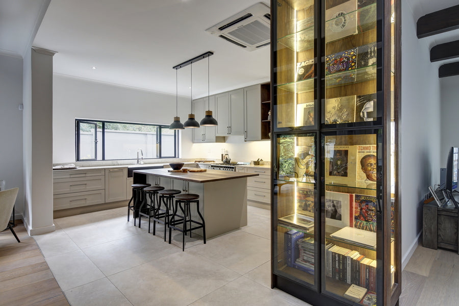 Modern kitchen with a glass display cabinet filled with books and decorative items.