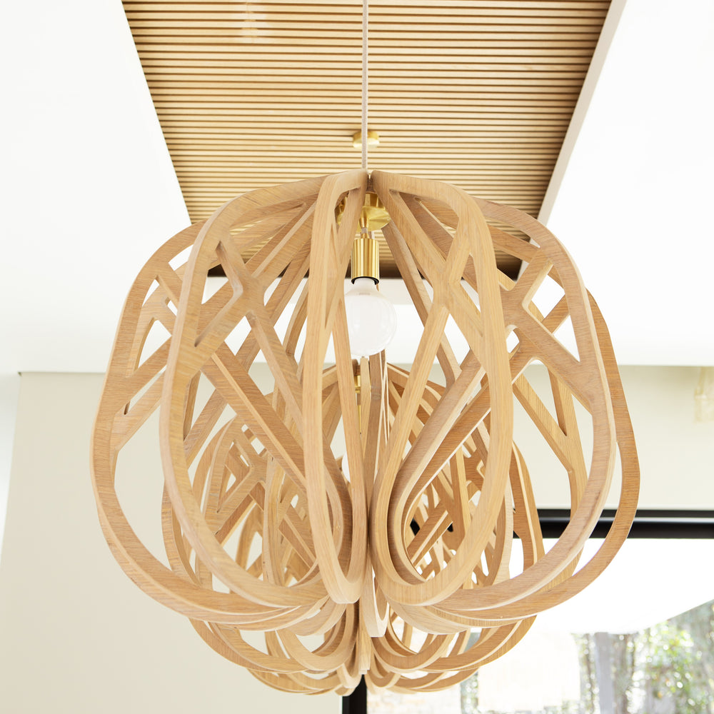 A spherical wooden pendant light fixture made of interlocking curved wooden rings, suspended from a ceiling with a slatted wood panel and white wall visible in the background.